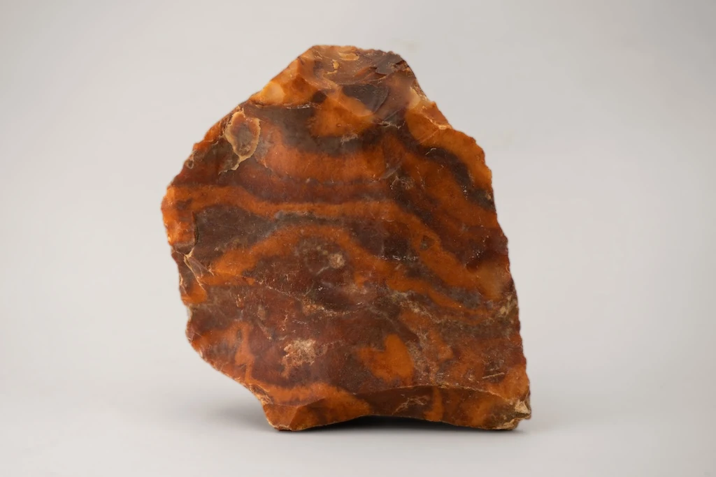 Couleur du sang et du feu, couleur du luxe et du pouvoir, le rouge est l’une des premières couleurs que l’homme a produites et déclinées en de multiples nuances : ici un outil taillé en silex et à patine rouge