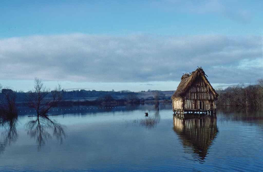 Depuis les premières découvertes, les sites palafittiques ne cessent de livrer des trésors archéologiques : restitution d’habitat dans le lac de Chalain, dans le Jura français.